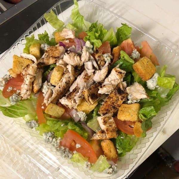 Grilled chicken salad with lettuce, tomatoes, red onions, croutons, and blue cheese crumbles.